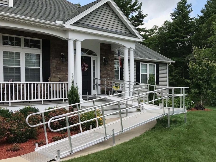 A wheelchair ramp leads up to the front door of a newly built home