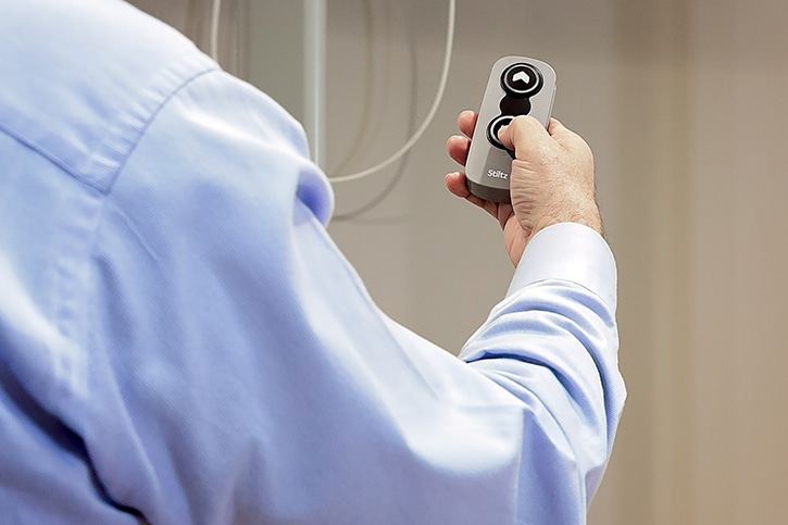 a long winding metal ramp that zig zags up a steep hill next to a cement staircase
