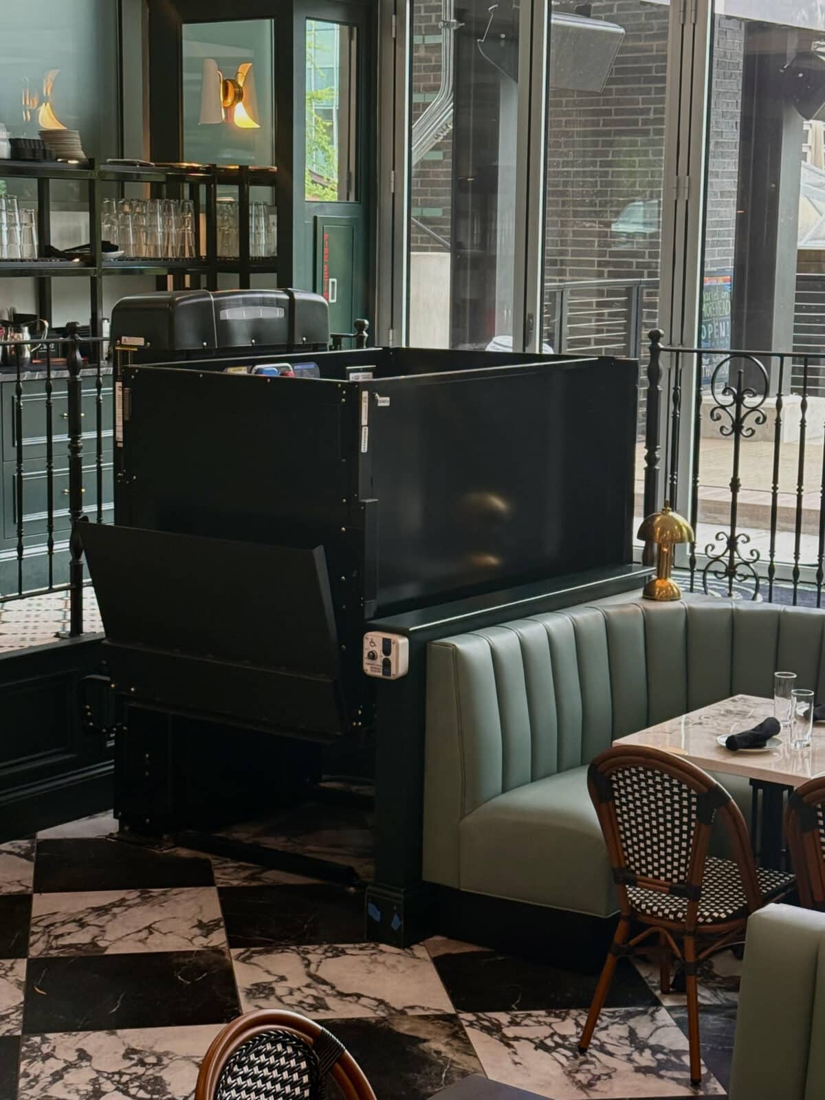 NDACLT - VPL 2 A black commercial vertical platform lift at a diner.