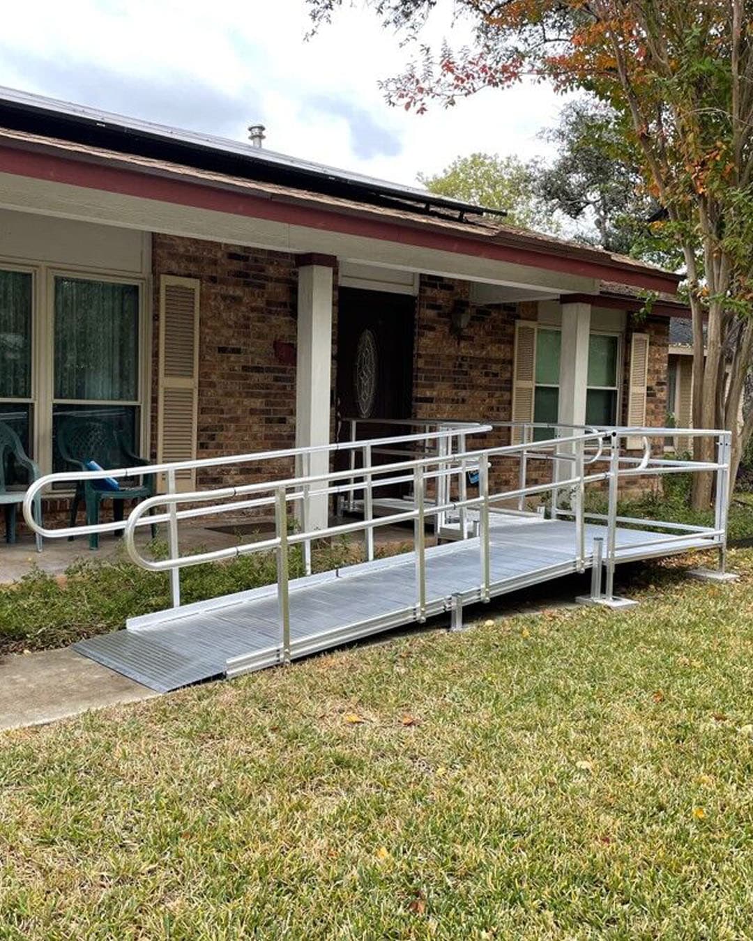 Three men in uniform stand outside next to a pond and discuss build plans