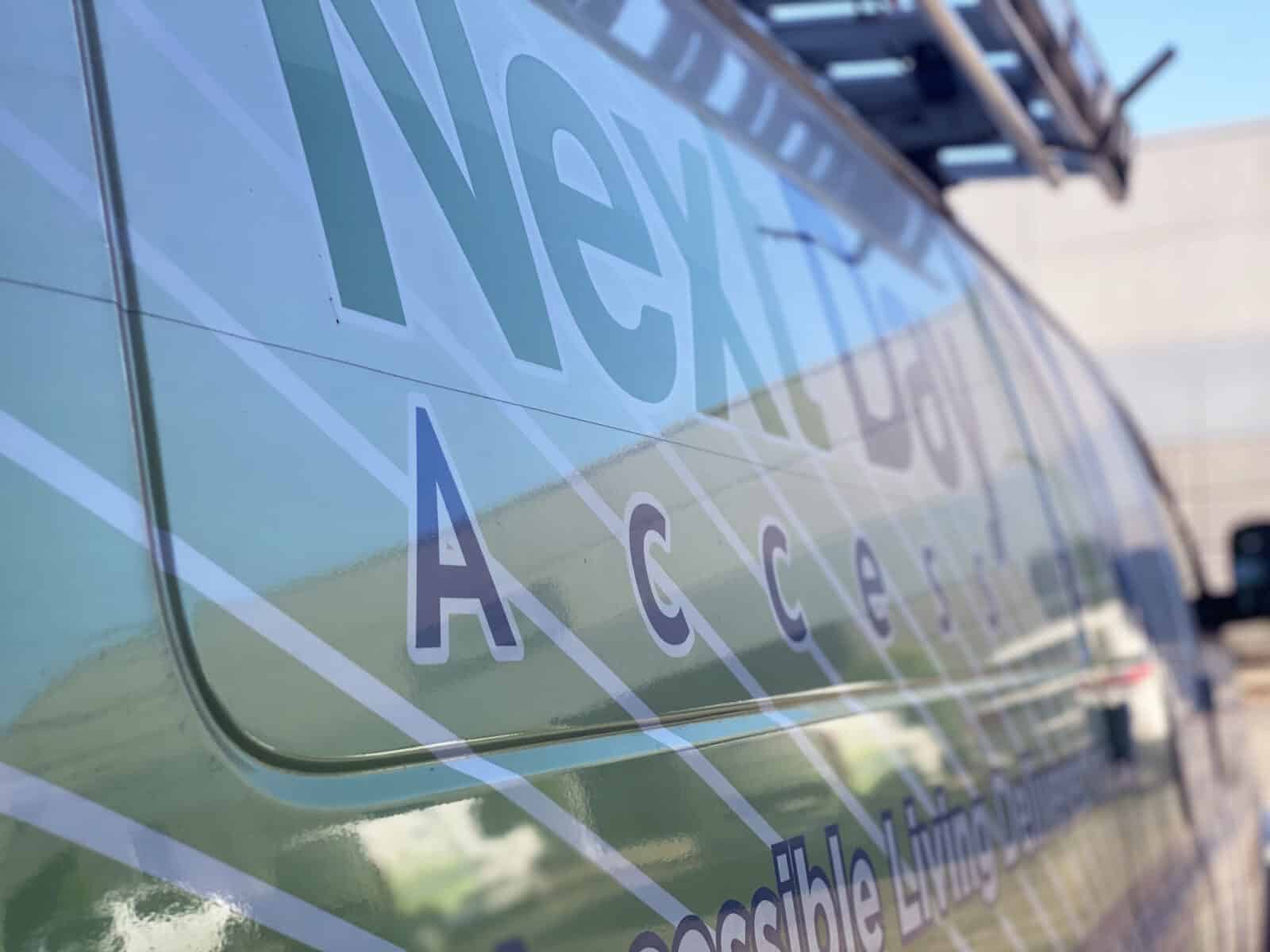 Close-up of a service van with "Next Day Access" text and logo visible on the side panel.