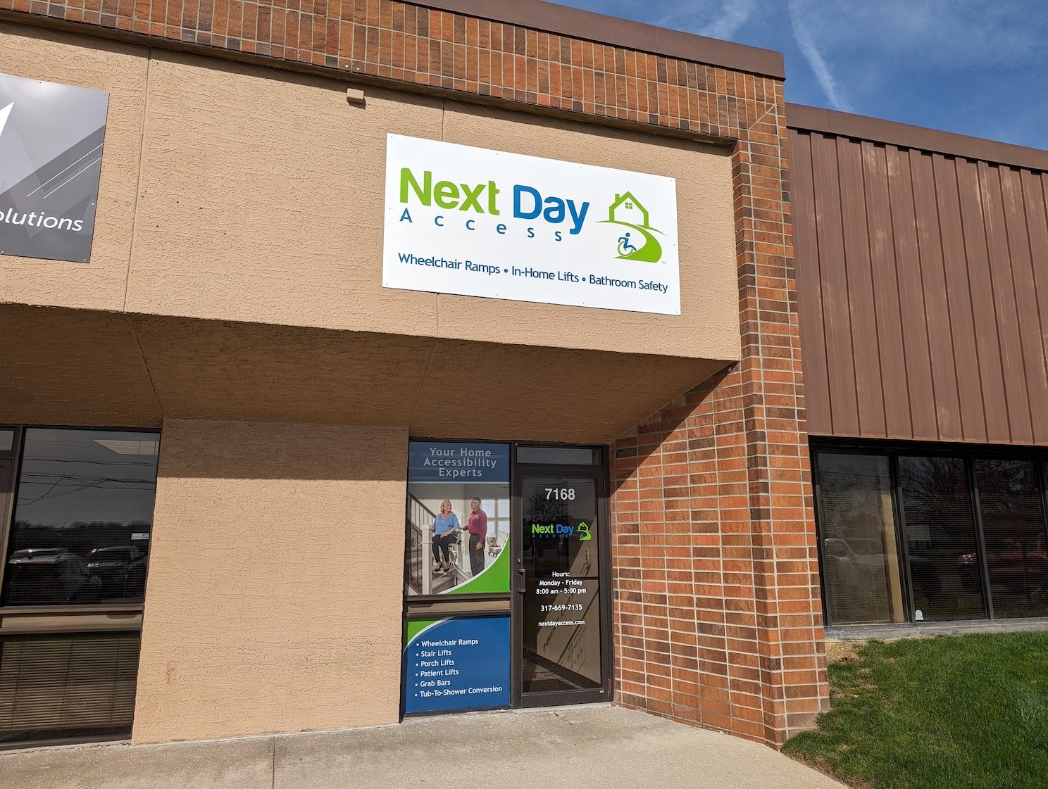 A crew in uniform installing a wheelchair ramp outside of a homeowner's front door