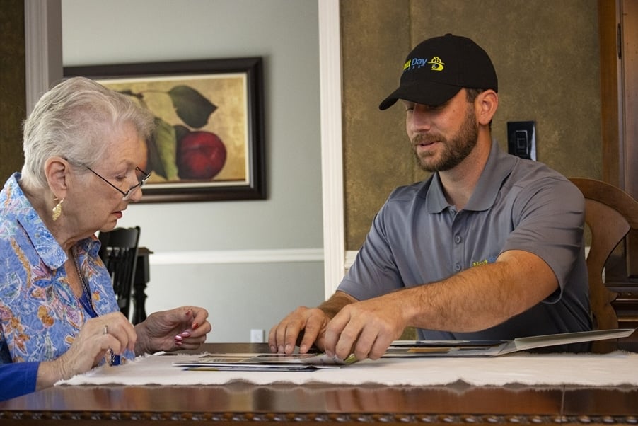 A homeowner sits at a table with a Next Day Access employee and discusses plans