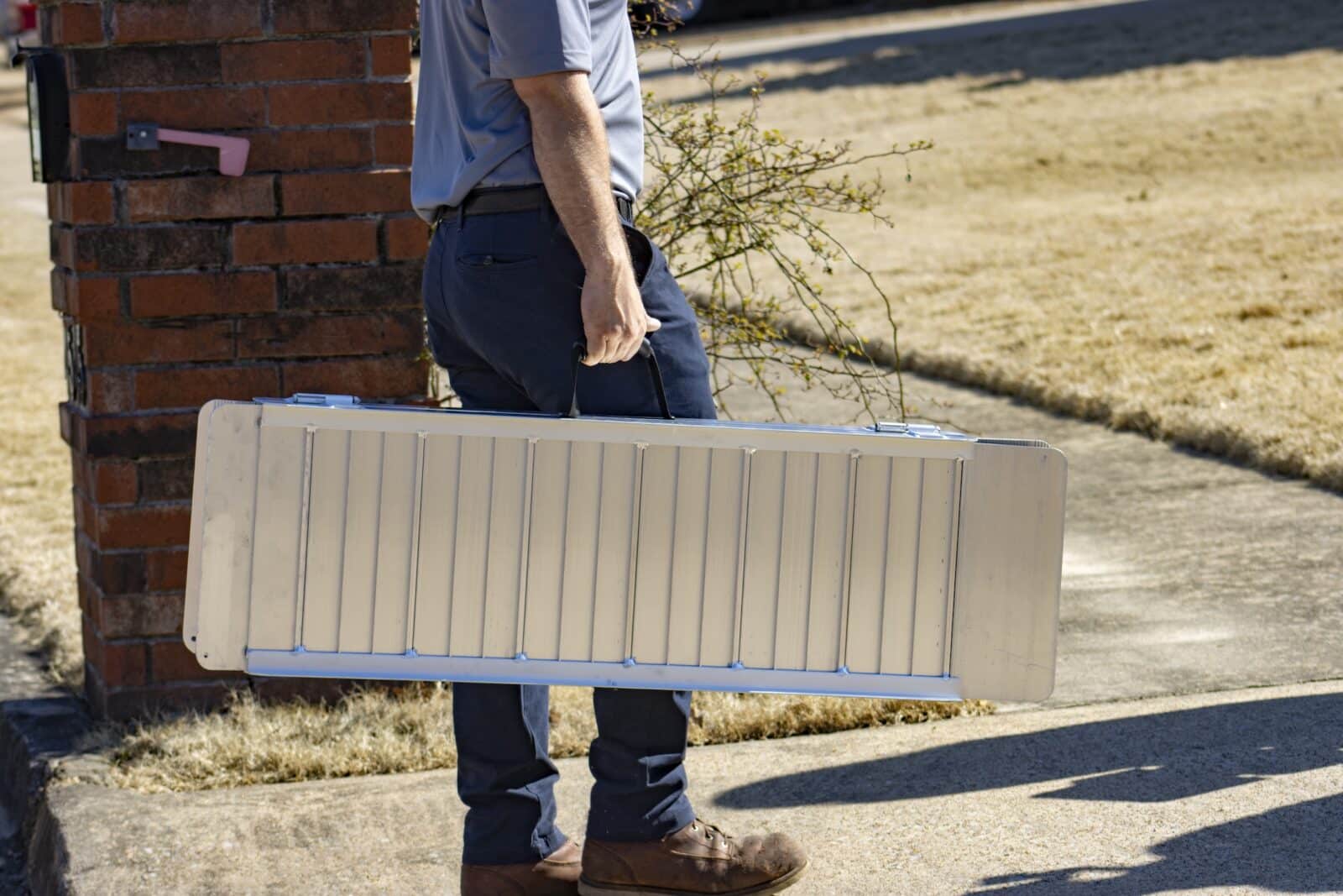 a blue motorized scooter sits unattended outside in a driveway