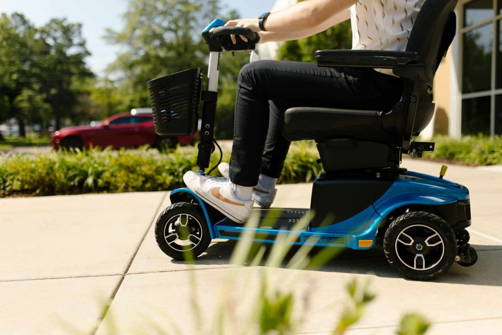 closeup of a motorized scooter riding down the sidewalk
