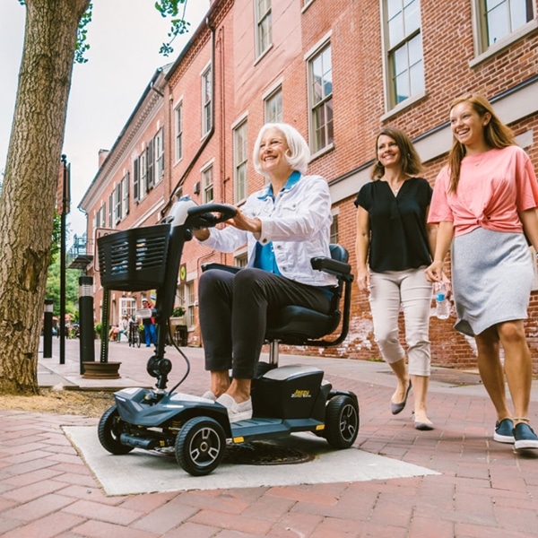 riding-scooter riding an electric scooter next to family on nicely paved city streets