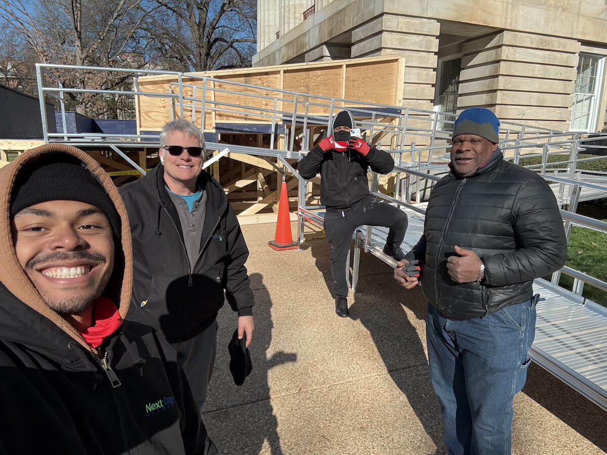 Modular aluminum wheelchair ramp installed along the exterior stone facade of the North Carolina State Capitol.