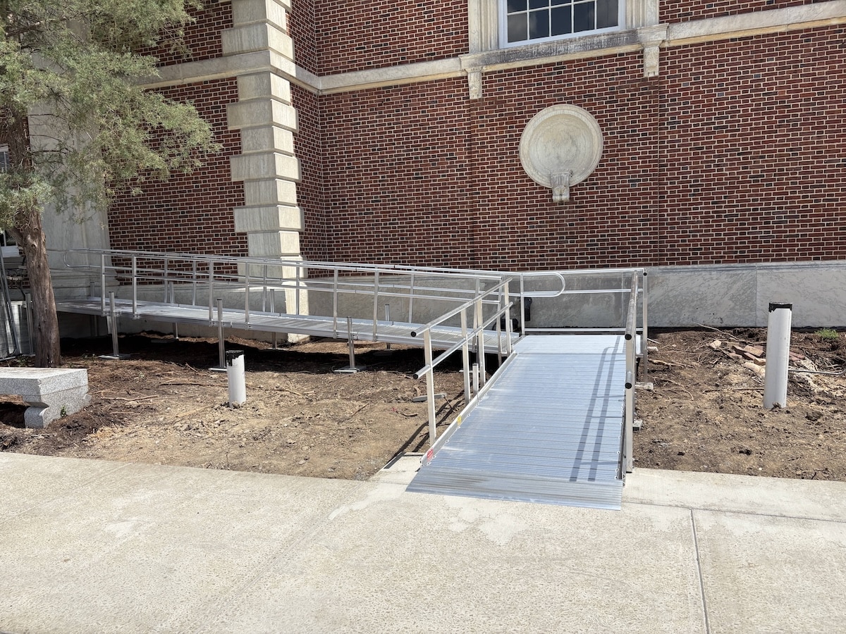 Switchback modular aluminum wheelchair ramp leading to a brick building at Duke University.