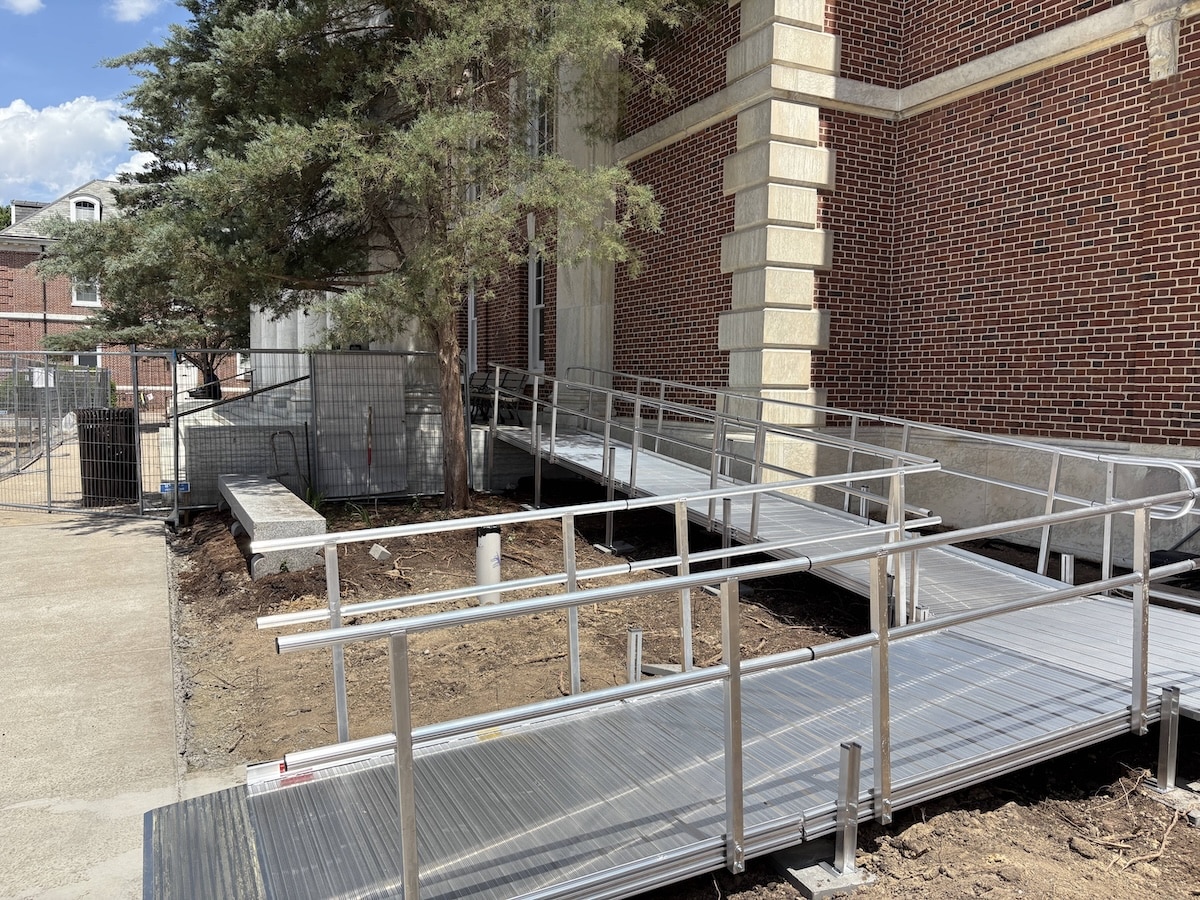 Angled view of an ADA-compliant aluminum wheelchair ramp and handrails at Duke University.