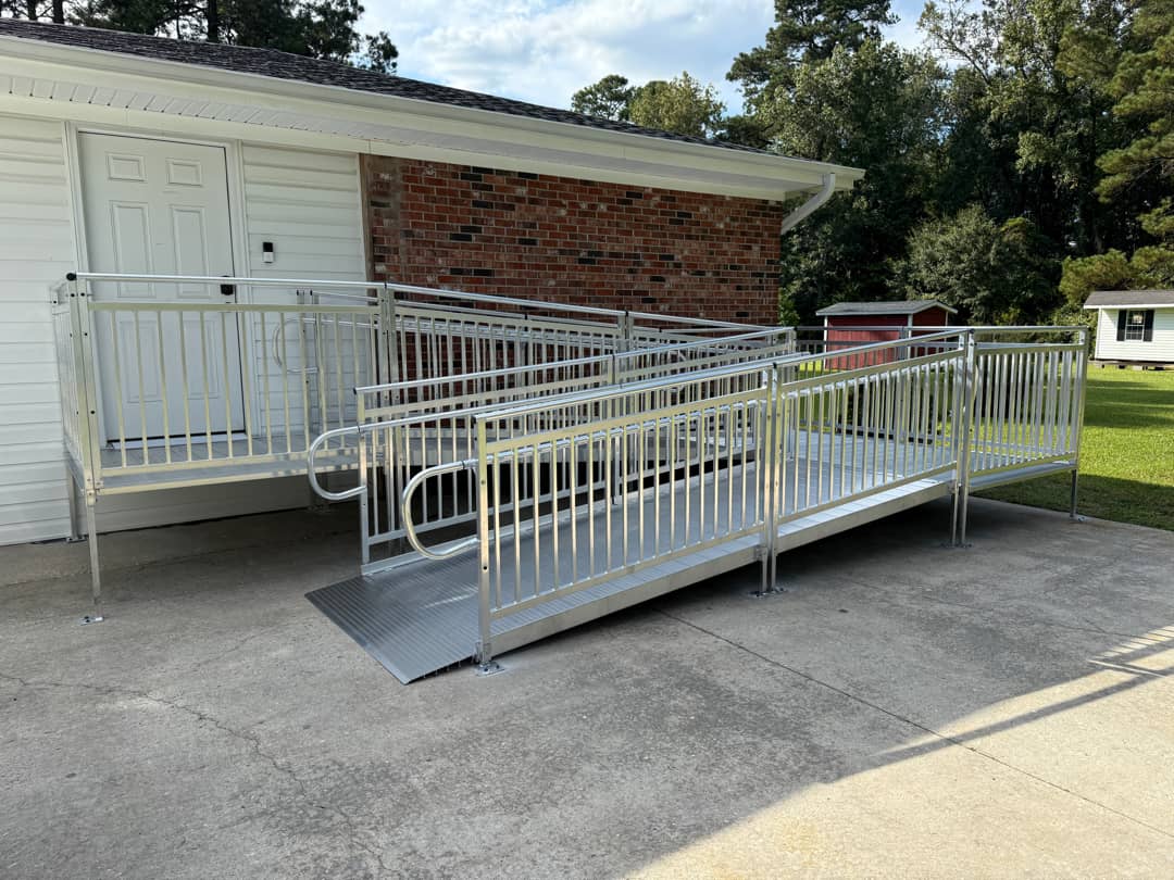 Angled view of a commercial aluminum wheelchair ramp leading to the entrance of a local government office.