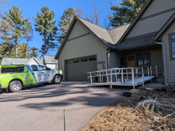 A wheelchair ramp leads up to the front door of a newly built home
