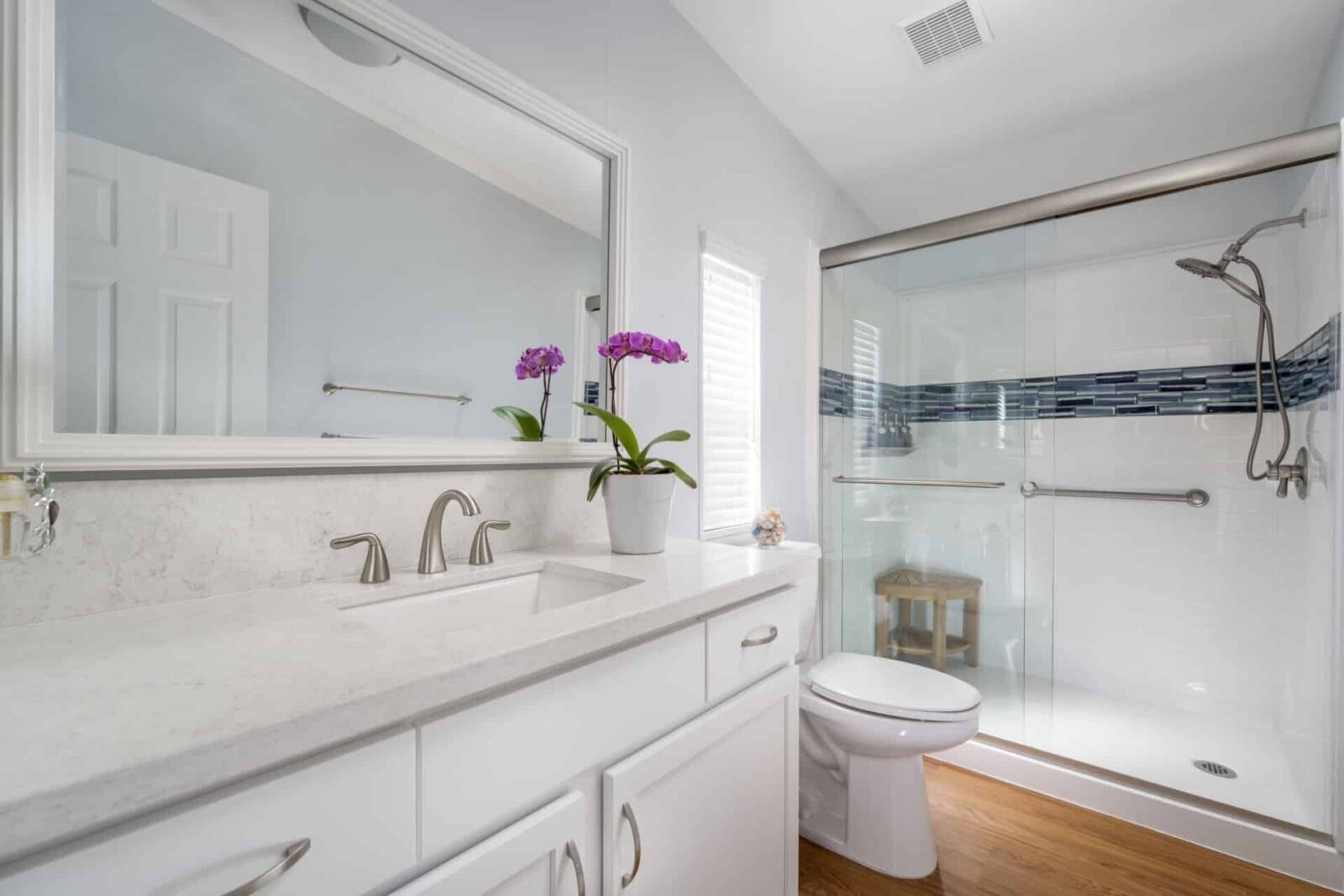 An angled shot of an all white bathroom with safety bars installed
