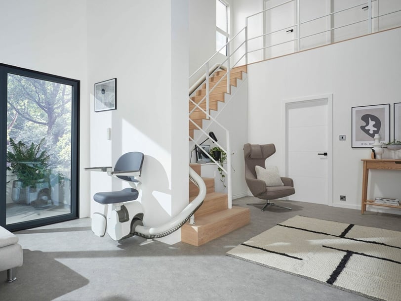 A chairlift wraps around an angled staircase in an upscale home