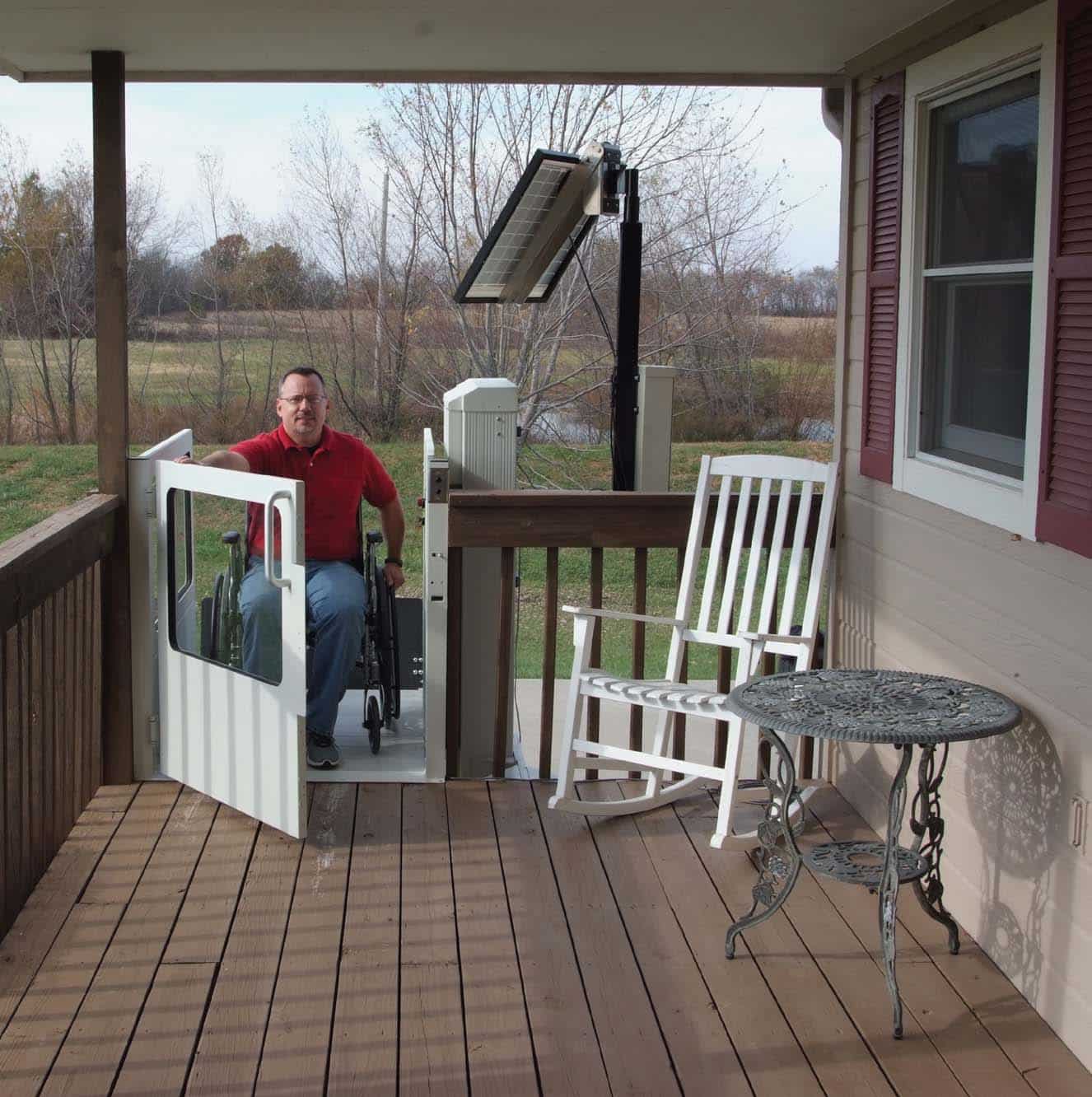Man opens the door of his porch lift at the top of his deck