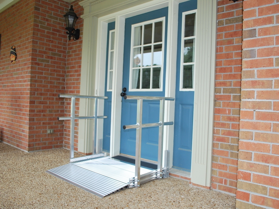 light brick home with a blue front door and small wheelchair ramp in front