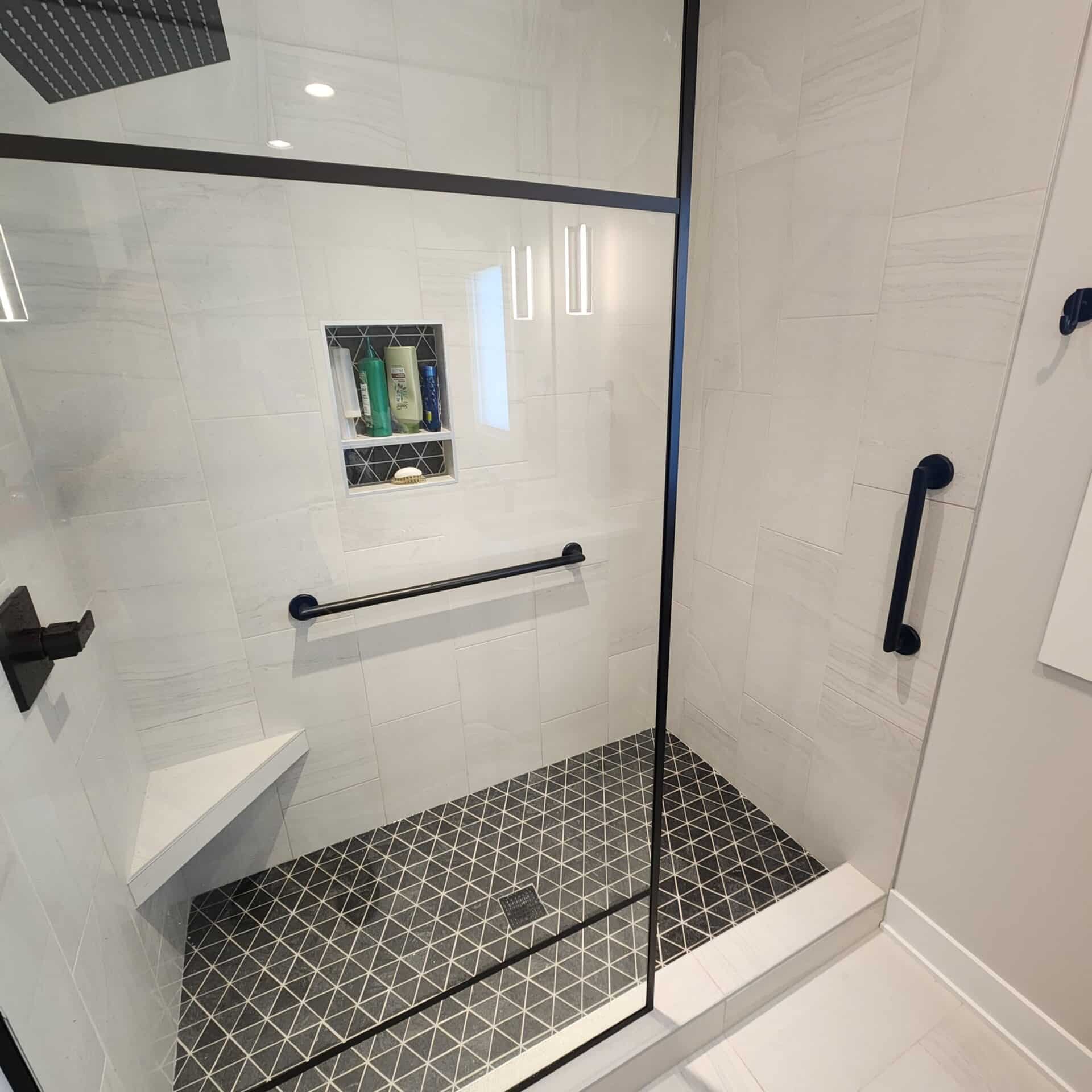 a black and white bathroom with safety bars installed in the shower