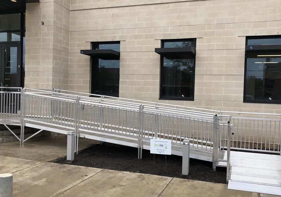 exterior of a stone office building with a ramp installed leading up to the front door