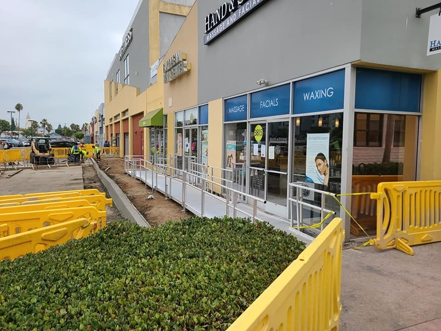 Wheelchair ramp installed during construction of a parking lot in front of new retail stores