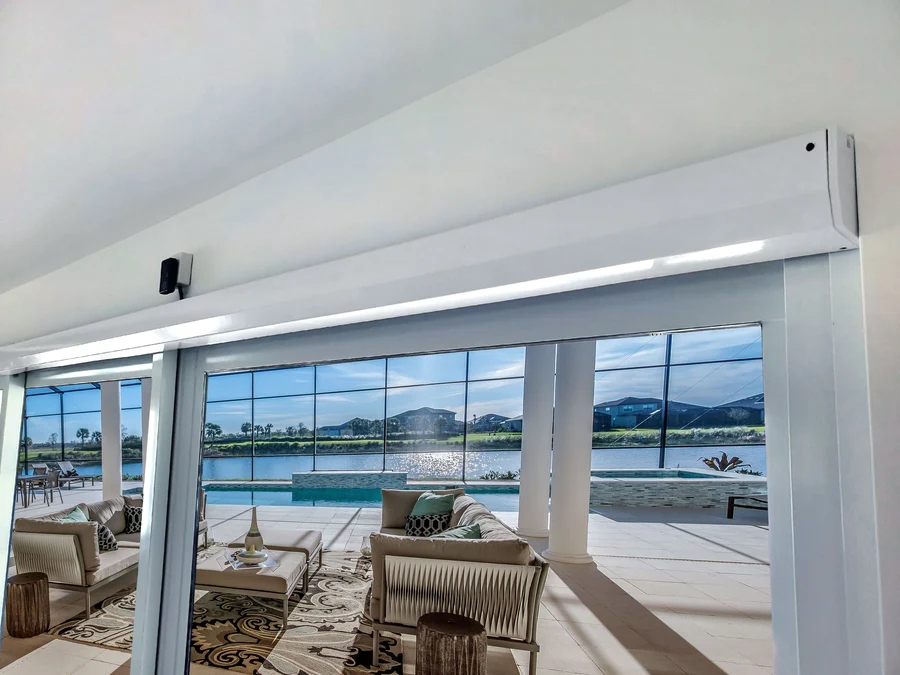 A wide door opener sits above a long sliding glass door with a luxurious sunroom on the other side