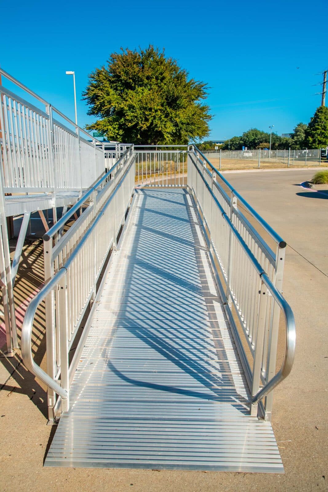 A group of four Next Day Access employees smile at the bottom of a small staircase