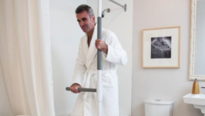A man holding onto a shower saftey pole