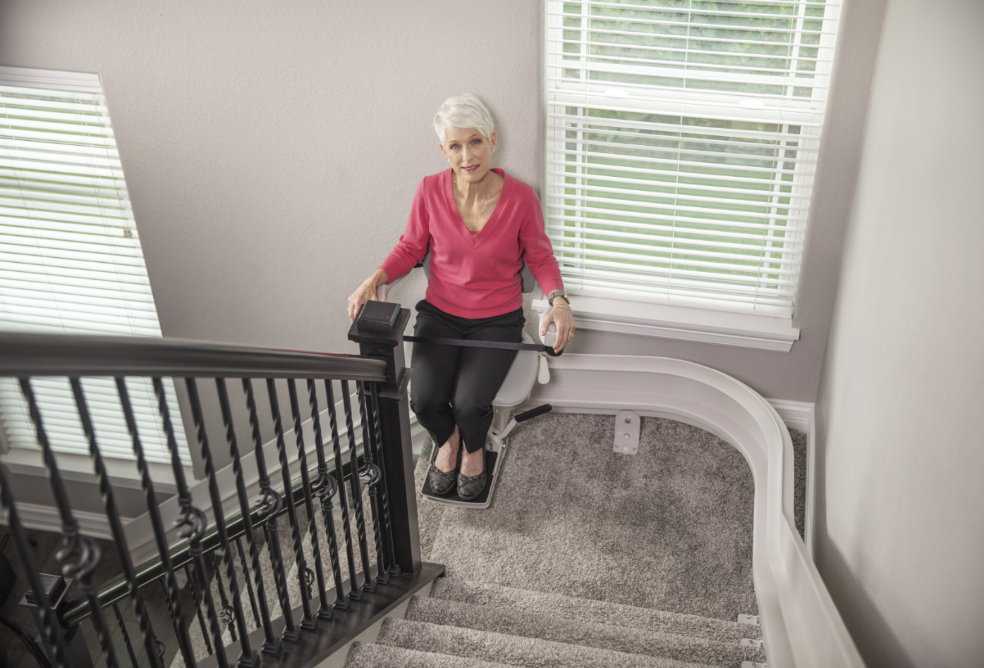 Customer using a Bruno Indoor Curved stairlift to move up the stairs