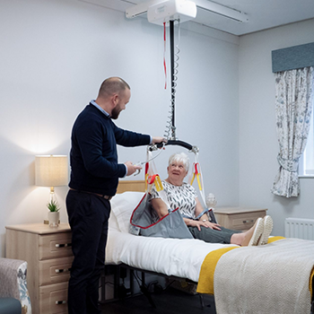 caretaker looking at the patient lift for their loved one