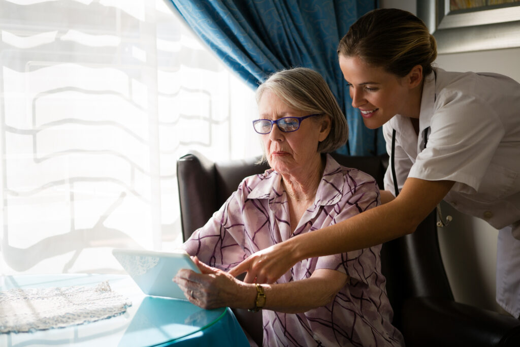 live independently at home - female doctor assisting woman in using digital tab ZP2QAT8