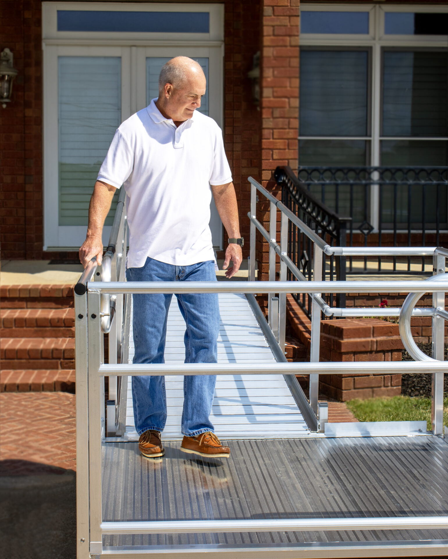 Customer using a modular wheelchair ramp to walk out of the front of their home safely