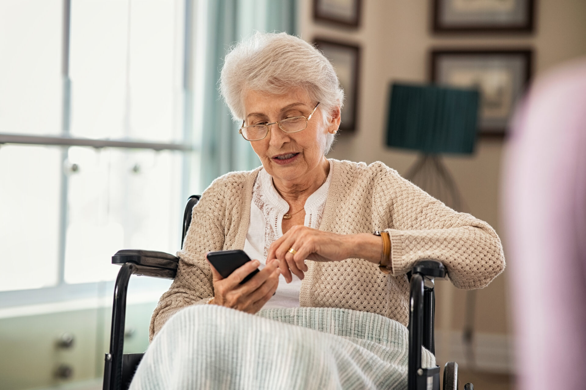 senior woman using smartphone on wheelchair VEC6K7R
